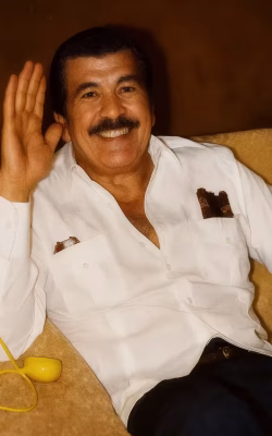 Smiling man wearing a white shirt sitting at a table